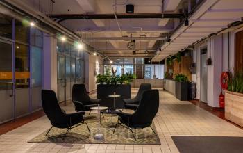 Modern office space at Van Nelleweg 1 in Rotterdam Delfshaven, featuring contemporary furniture and ample lighting, ideal for office space rental.