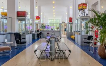 Spacious office hallway at Van Nelleweg 1, Rotterdam Delfshaven featuring seating area and retro decor, ideal for office space rental.