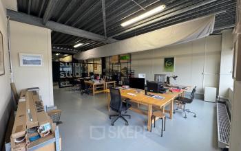 Interior view of a furnished office space at Van Helmontstraat 17-23 in Rotterdam Delfshaven, showcasing wooden desks and modern office chairs available for rent.