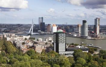 Aerial view of Rotterdam Delfshaven, showcasing office to rent at Westerlaan 10-65, set against a backdrop of the cityscape with prominent modern buildings and the iconic Erasmus Bridge.