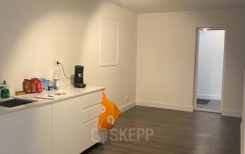 Interior view of an office to rent at Haringvliet 76, Rotterdam, featuring clean lines, neutral decor, cabinetry, and track lighting, ideal for creating a functional workspace.