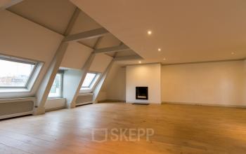 Spacious unfurnished office interior with wooden flooring and sloped ceilings located at Haringvliet 92, Rotterdam, perfect for office space rental.