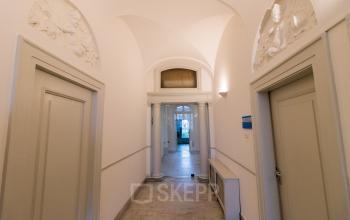 A clean, bright corridor with marble floors at Haringvliet 92, Rotterdam, leading to an office interior available for office space rental. Elegant architectural details add charm.