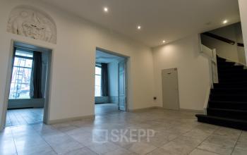 Spacious interior with tiled floors and bright natural light at Haringvliet 92, perfect for office space rental. Elegant lighting and architectural details provide a modern yet timeless atmosphere.
