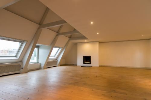 Spacious unfurnished office interior with wooden flooring and sloped ceilings located at Haringvliet 92, Rotterdam, perfect for office space rental.