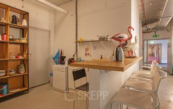 Kitchenette area with counter and barstools at an office space for rent at Zomerhofstraat 71, Rotterdam North.