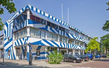 Exterior view of the blue and white striped office building located at Zomerhofstraat 71, Rotterdam North, suitable for office space rental.