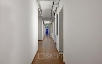 Long, well-lit corridor with white walls and brown flooring in the office building at Vijverhofstraat 47, Rotterdam North, Rotterdam.