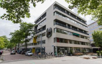 Exterior view of the office building at Zomerhofstraat 84, Rotterdam North, highlighting multiple floors with balconies and street parking available nearby.