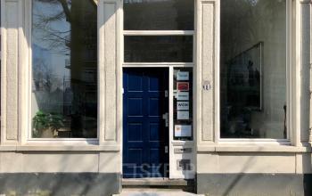 Charming blue door entryway of office space rental at Van der Takstraat 8, surrounded by large windows in Rotterdam Noordereiland.