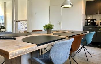 Modern office space rental at Van der Takstraat 8, Rotterdam Noordereiland featuring a well-lit meeting area with stylish furnishings and a kitchenette.