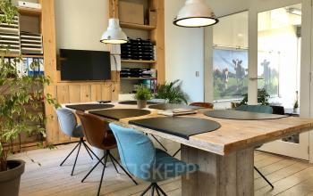 Bright and stylish office space rental at Van der Takstraat 8, Rotterdam Noordereiland with wooden tables, comfortable chairs, and modern lighting.