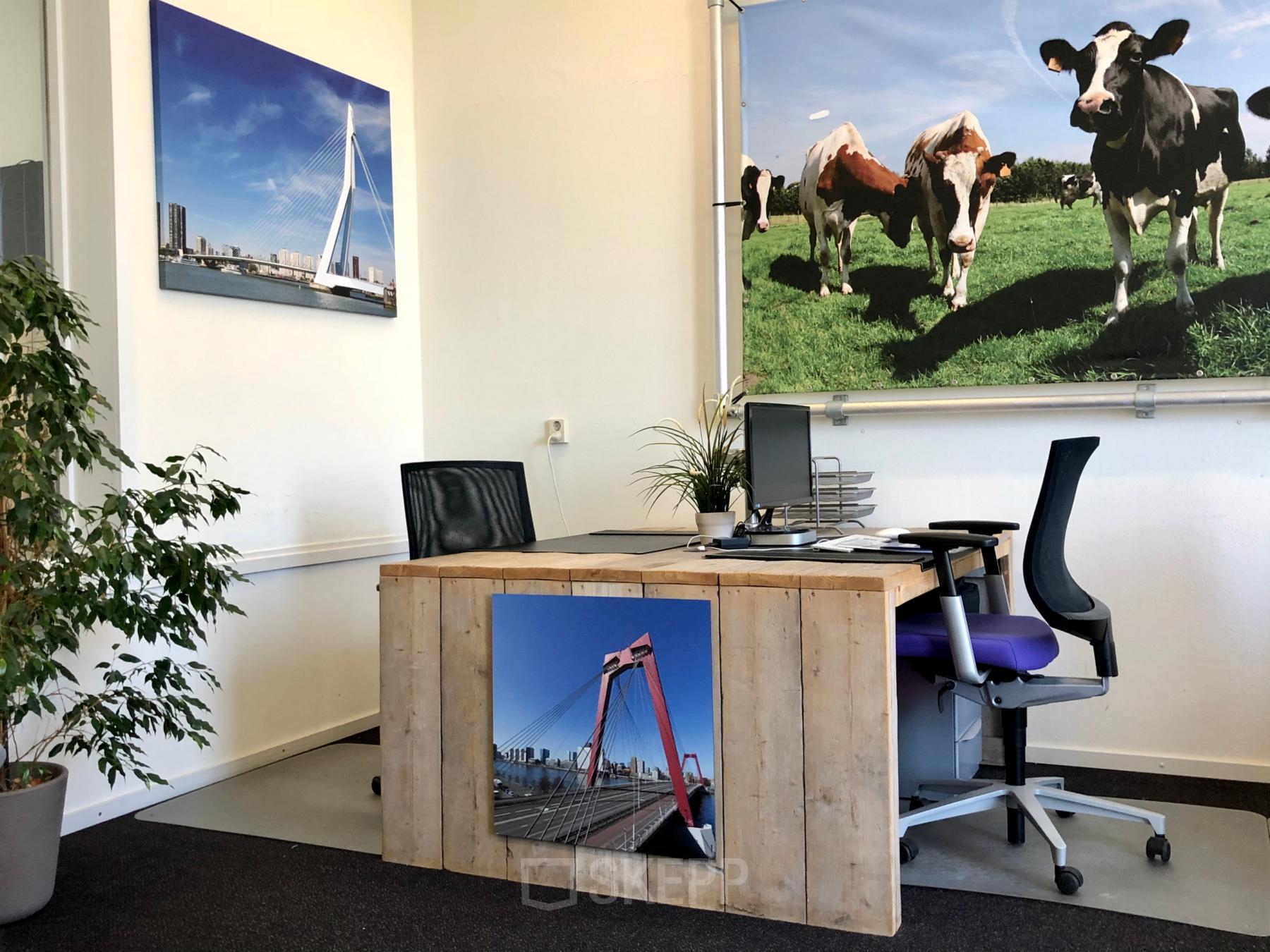 Modern office space rental at Van der Takstraat 8 in Rotterdam Noordereiland with a desk and vibrant local photography on the walls.