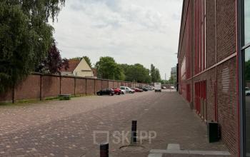 Exterior view of Scheepsbouwweg 29 in Rotterdam Waalhaven, featuring a street scene with cars parked along the side.