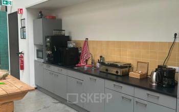 Furnished office pantry at Scheepsbouwweg 29, Rotterdam Waalhaven featuring gray cabinets and appliances. Ideal for office space rental.
