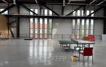 Spacious open floor plan at Scheepsbouwweg 29, Rotterdam Waalhaven, featuring large windows and minimal furnishings.