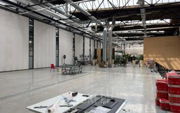 Spacious industrial-style office space for rent at Scheepsbouwweg 29, Rotterdam Waalhaven with high ceilings and natural light, showcasing equipment and unpacked items.