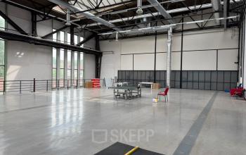 Spacious interior at Scheepsbouwweg 29, Rotterdam Waalhaven, featuring a large open area with industrial ceilings and minimal furnishings, ideal for office space rental.