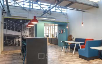 Modern lounge area in an office to rent at Overschieseweg 34, Schiedam, featuring contemporary seating and bright overhead lights.