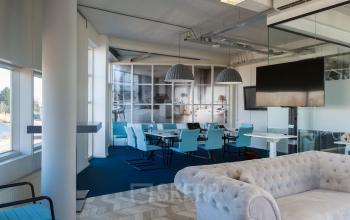 Modern office space rental at Overschieseweg 34, Schiedam with a large meeting area, glass partitions, and comfortable seating.