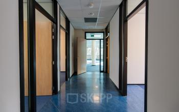 Interior hallway view of office space rental at Noordvest 18, Schiedam, featuring open doors and natural lighting.