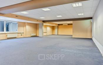 Spacious open floor plan at de Brauwweg 52-66 in Schiedam, ideal for office space rental. Features neutral tones and large windows for natural light.