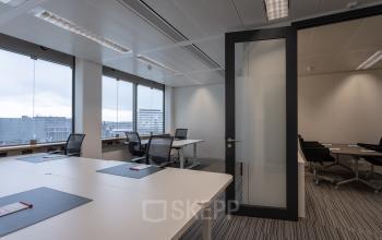 Spacious, furnished office at Schiphol Boulevard 127, featuring modern desks and large windows, ideal for office space rental at Schiphol Airport.