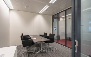 Modern conference room with glass walls, offering office space rental at Schiphol Boulevard 127, Schiphol Airport. Ideal for meetings.