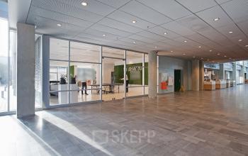 Spacious and modern office space rental at Evert van de Beekstraat 104, Schiphol, with green accents and glass partitions.