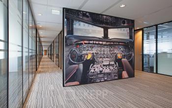 Modern office space rental at Evert van de Beekstraat 104, Schiphol, with a vibrant airplane cockpit art piece.