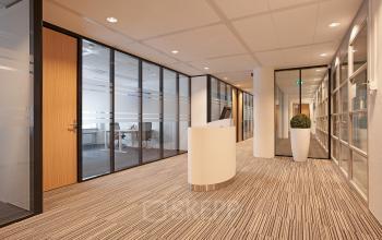 Modern office space rental at Evert van de Beekstraat 104, Schiphol with glass partitions and a welcoming reception desk.