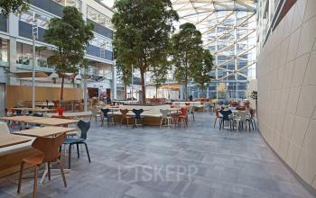 Spacious and well-lit office space rental at Evert van de Beekstraat 104, Schiphol with a variety of modern seating options and a lively atmosphere.
