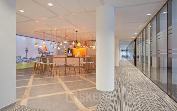 Modern office space rental at Evert van de Beekstraat 104, Schiphol, featuring a bright lounge area with stylish lighting and comfortable seating.
