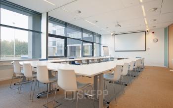 Modern conference room with a large table and chairs at office space rental, Evert van de Beekstraat 104, Schiphol.