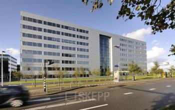 Modern office building at Evert van de Beekstraat 310, Schiphol Airport, ideal for office space rental with a sleek, glass façade and landscaped surroundings.