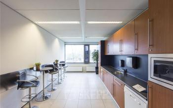 Kitchenette with modern appliances and seating area in office space located at Evert van de Beekstraat 310, Schiphol Airport.