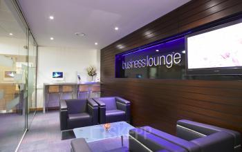 Modern business lounge in office space rental at Evert van de Beekstraat 310, Schiphol Airport, with sleek furniture, glass partitions, and a cozy seating area.