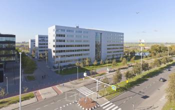 Six-story modern office building at Evert van de Beekstraat 310-1, Schiphol Airport, available for office space rental, with landscaped surroundings and convenient access roads.