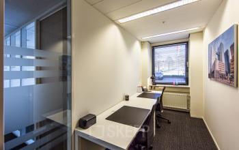 Interior view of office space rental at Evert van de Beekstraat 310, Schiphol Airport, featuring two desks and large window.