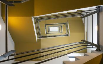 Interior view of a modern office stairwell with yellow and white walls and metal railings at Boeingavenue 223 – 239, Schiphol Rijk, Schiphol.
