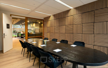 Modern conference room with a large wooden table and upholstered chairs available for office space rental at Boeing Avenue 1-19, Schiphol Rijk.