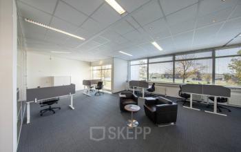 Modern office space rental at Beechavenue 54-62, Schiphol with desks, chairs, and a comfortable seating area by the window.