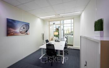 Office space rental with a tidy desk, chair, and wall art at Beechavenue 54-62, Schiphol, inviting professionals to focus and innovate.