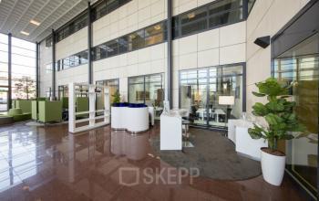 Spacious and well-lit reception area of an office to rent at Beechavenue 54-62, Schiphol, with modern furniture and plants.