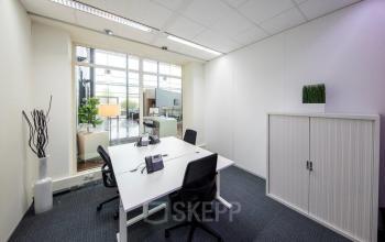 Modern office space rental at Beechavenue 54-62, Schiphol showcasing a sleek, well-lit room with a workstation and chairs.