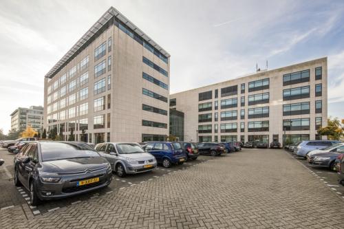 Exterior view of Beechavenue 54-62 office space rental in Schiphol, showcasing its modern facade and adjacent parking lot.