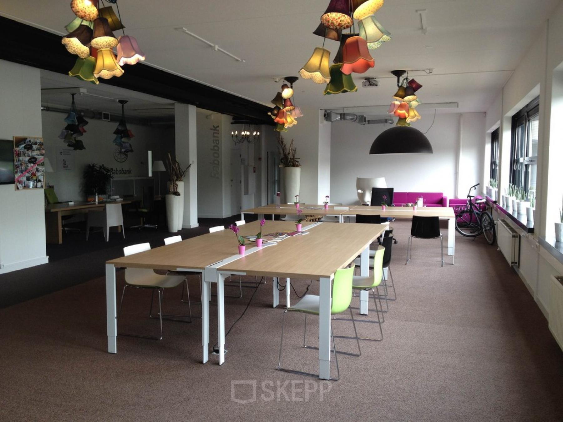 Bright and contemporary office space rental at Poststraat 8, Sittard, with a mix of traditional desks and informal meeting areas.