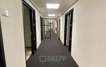 Office hallway at 200 Milaanstraat, Sittard, featuring several closed doors and neutral decor, ideal for office space rental.