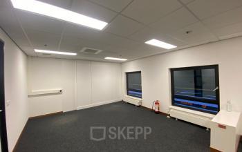 Unfurnished office interior at 200 Milaanstraat, Sittard, featuring carpeted floors, overhead lighting, and large windows, ideal for office space rental.