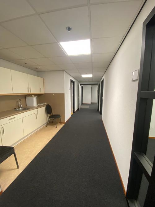 Bright hallway interior at 200 Milaanstraat, Sittard, featuring carpet flooring and a kitchenette area for convenient office space rental setup.